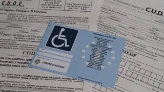 Documento di **verbale invalidità civile definitivo** con contrassegno per parcheggio disabili.